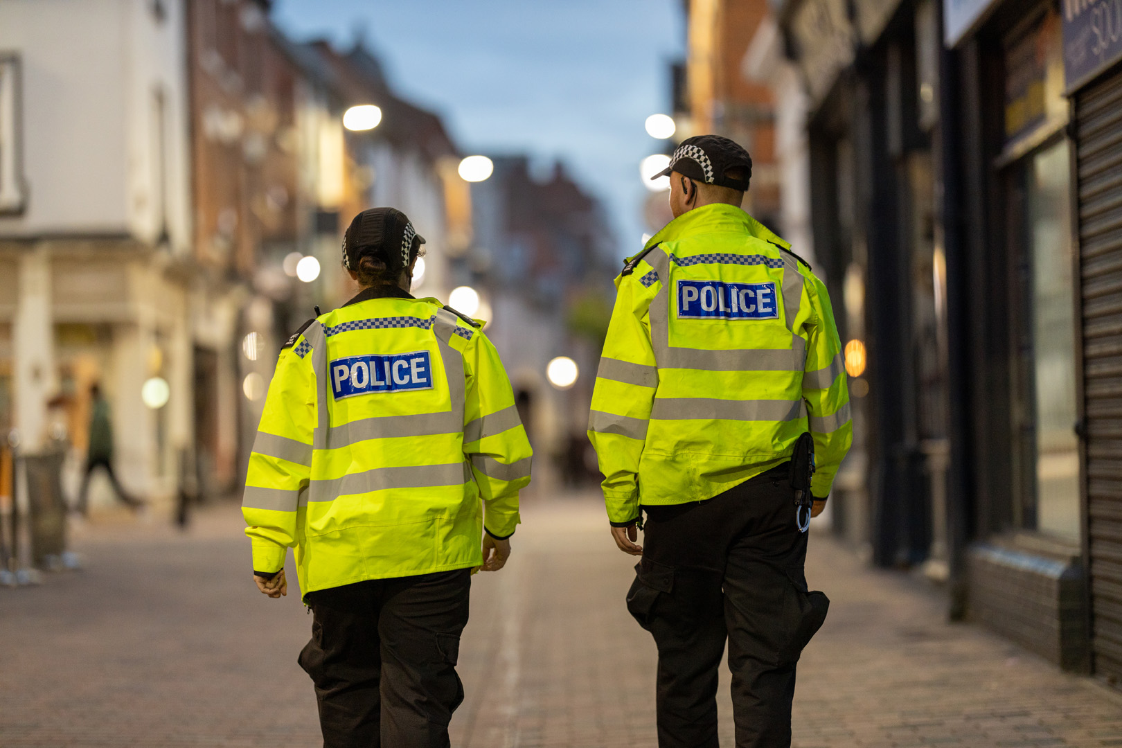 Two police officers walking down a street